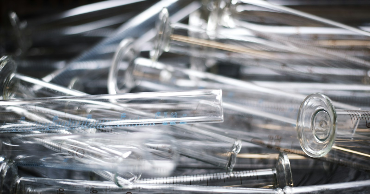 Clear measuring tubes and glass cylinders arranged in a laboratory.